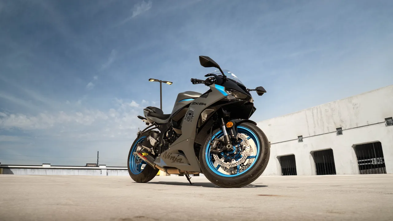 Kawasaki Ninja sportbike shot from a low angle on a rooftop against blue sky