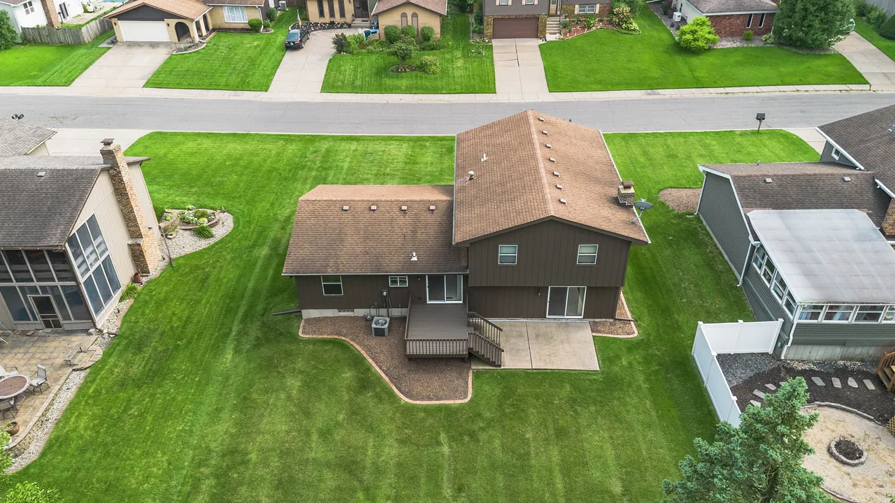 Aerial view over the rear of the property showing the roofline, deck and lot lines