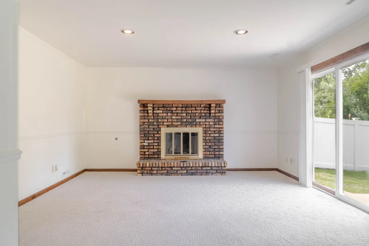 Living space with a brick fireplace and a sliding glass door onto the yard
