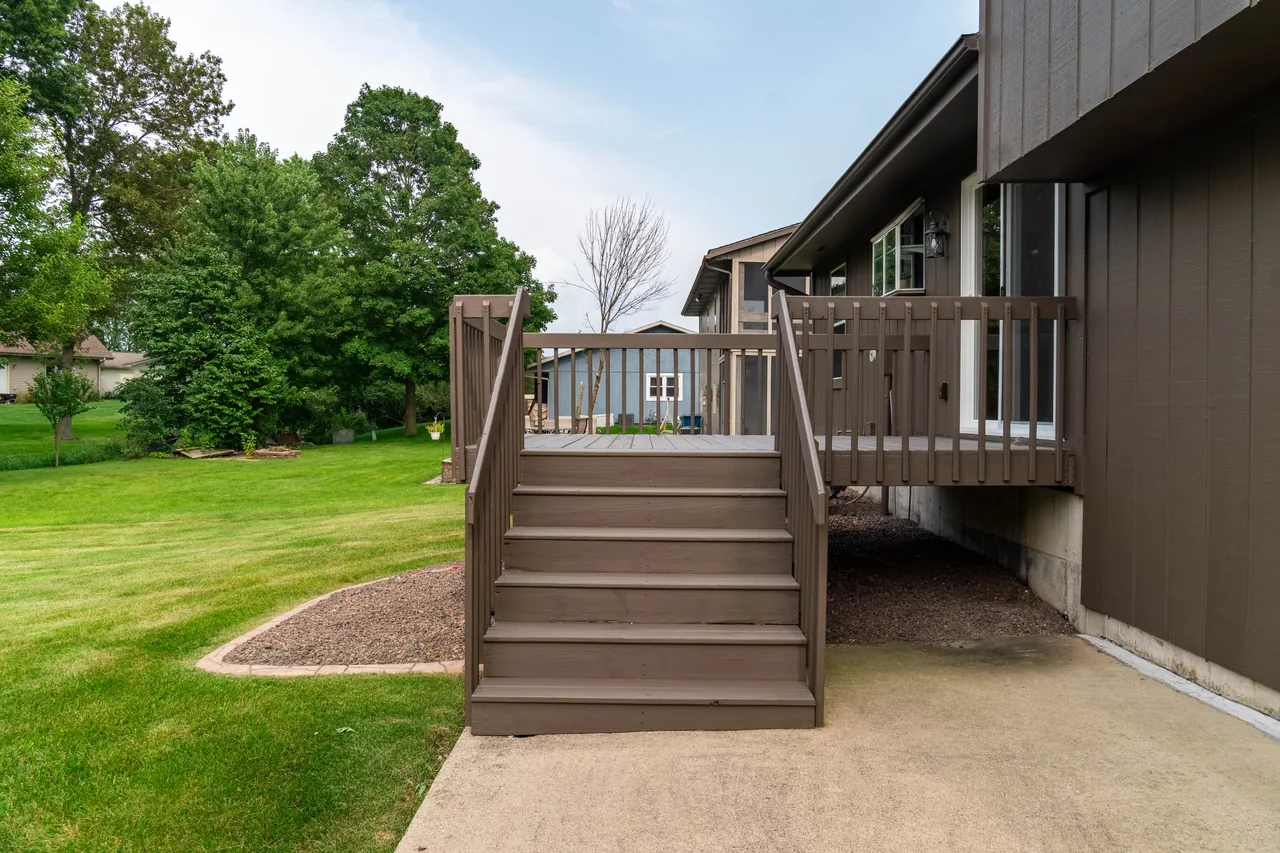 Wooden deck stairs leading down to the back yard and mature trees